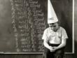Staged shot of boy wearing dunce cap.